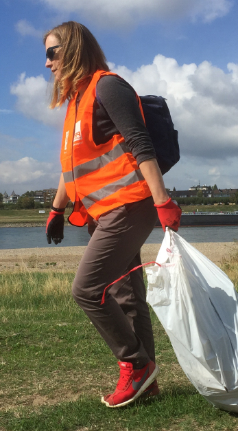 Teilnehmerin mit Handschuhen, Müllsack und Weste